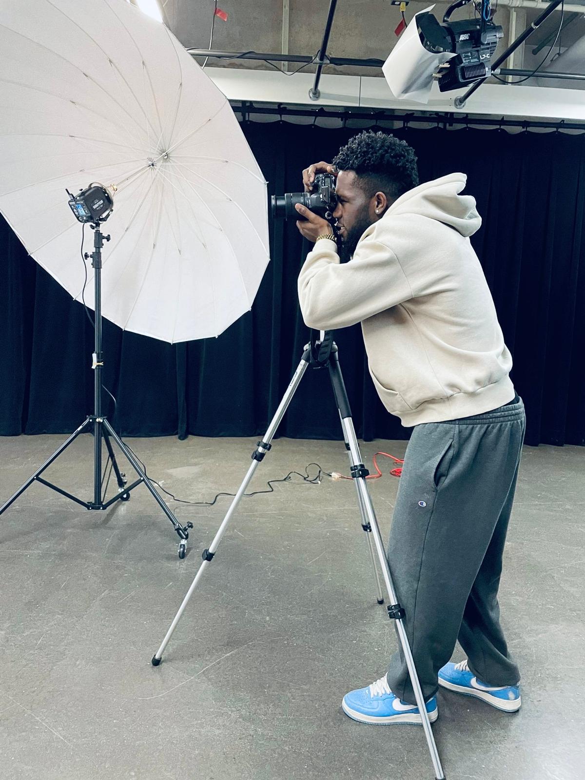 Franck Meryl Bibeki Itoo utilisant une caméra dans un studio photo